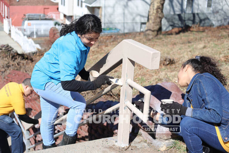 ASEZ volunteers painting a railing at Roberto Clemente Park.