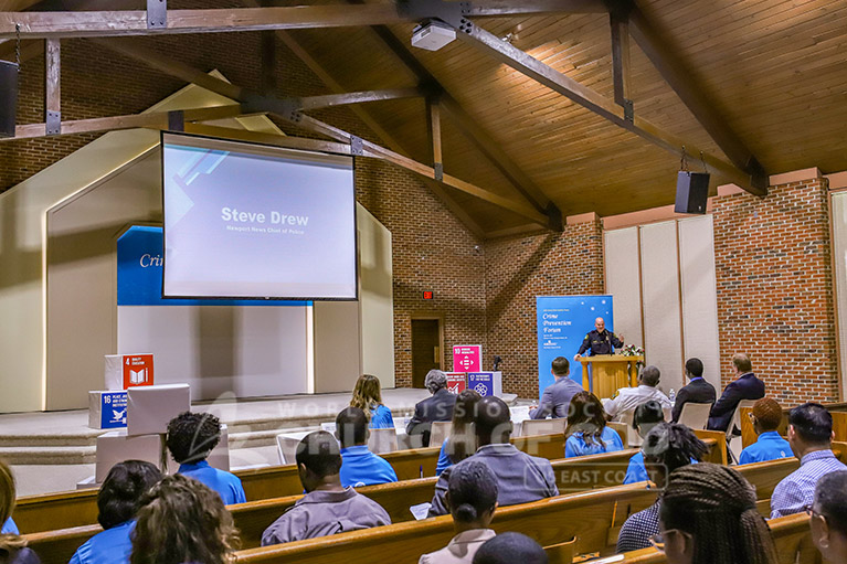 ASEZ volunteers and guests listen to Police Chief Steve Drew speak at the Crime Reduction Forum.