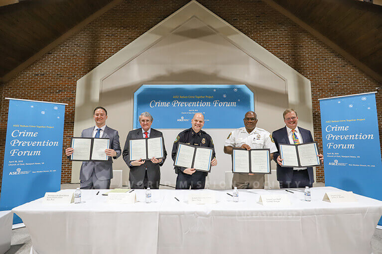 Police Chief Steve Drew, Sheriff Gabe Morgan, Professor Daniel Warman, and attorney Jeffrey Riddle hold up signed ASEZ MOUs.
