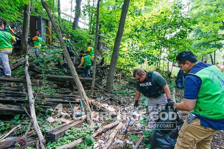 ASEZ WAO volunteer picking up trash with Middletown police officer at the Heritage Trail.