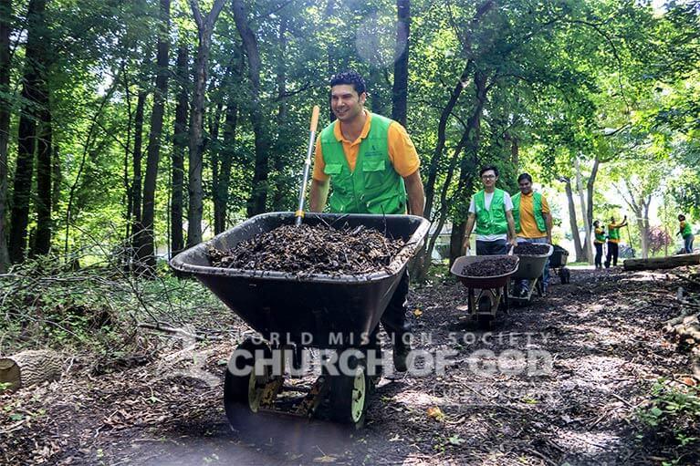 A volunteer of ASEZ WAO transporting mulch