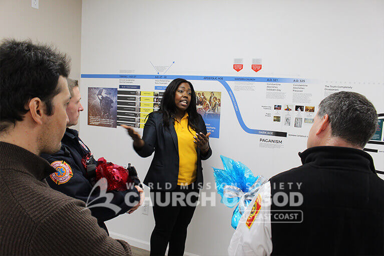 Church of God member giving the Westborough police officers a tour of the Christian history timeline