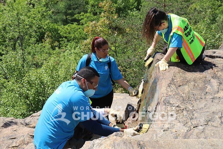 ASEZ student volunteers removing graffiti at the Cranberry Lake Preserve