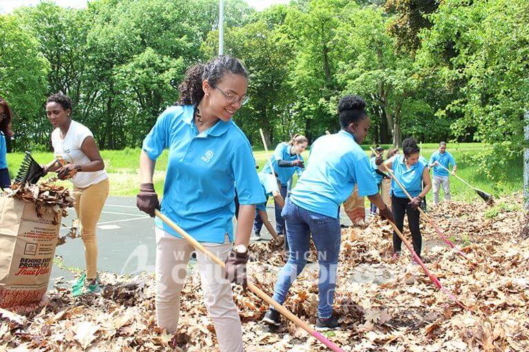 ASEZ volunteers removing dead leaves from tennis courts at Prospect Park in Troy, NY