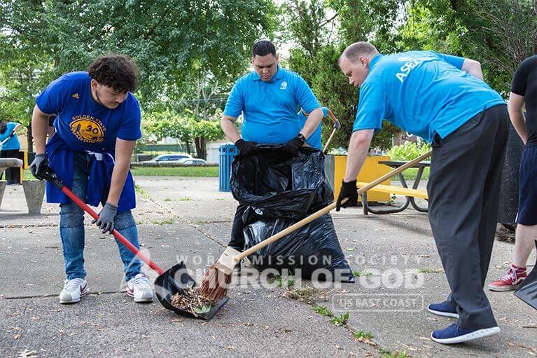 ASEZ volunteers sweeping the park grounds at Wrigley Park.